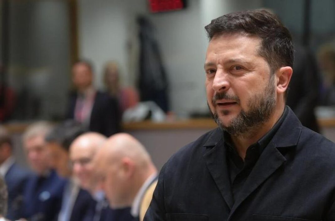 Zelenski se anota para una elección en plena guerra, con una condición: 60 días de tregua Un hombre de barba y ropa oscura habla de pie en una sala de reuniones con otras personas sentadas detrás