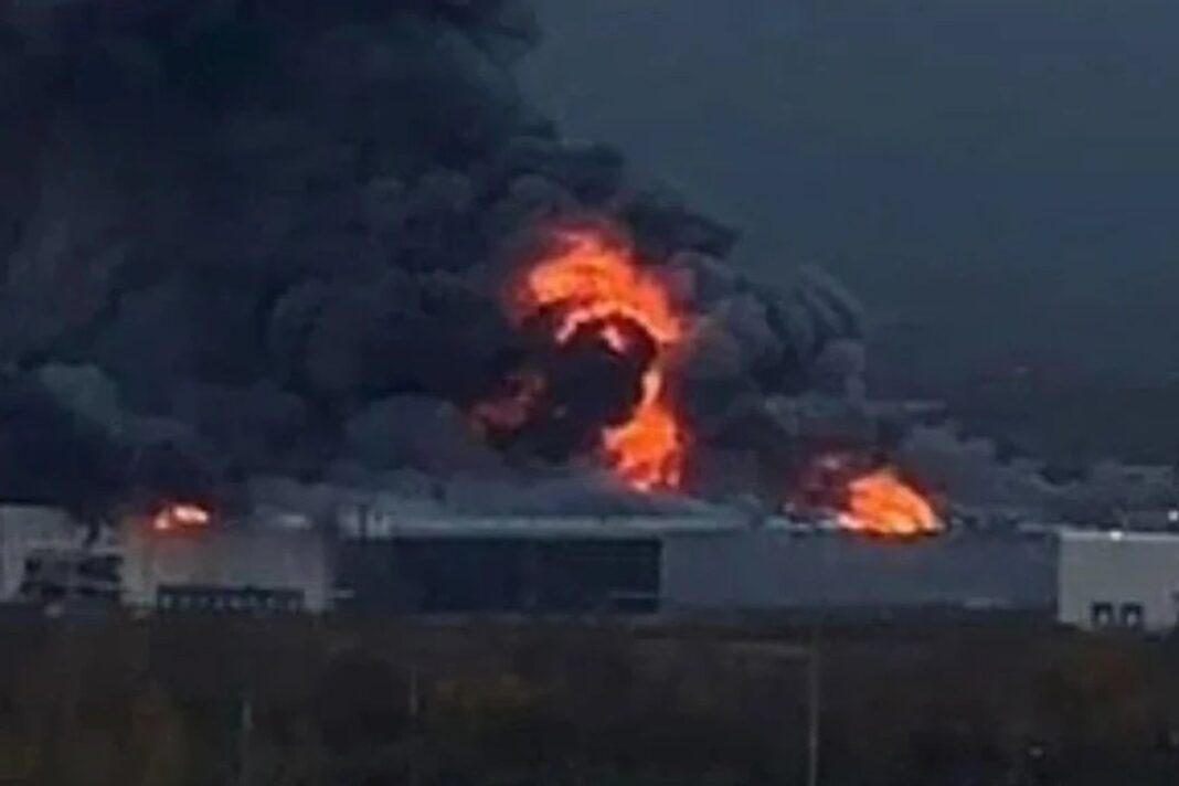 Un incendio con llamas y una densa columna de humo negro sobre un edificio industrial